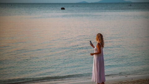 Eine Frau am Telefon an einem Strand