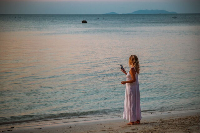 Eine Frau am Telefon an einem Strand