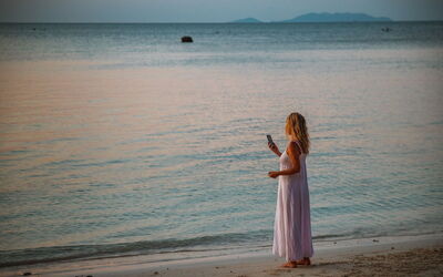 Eine Frau am Telefon an einem Strand
