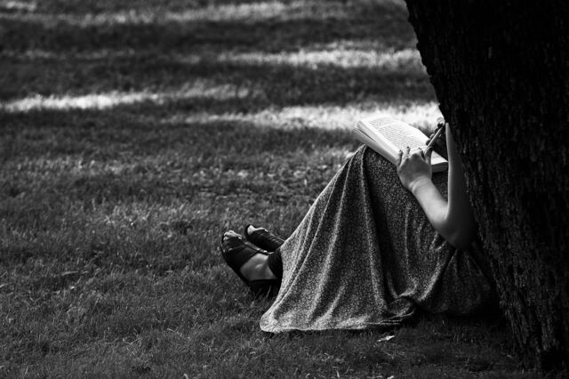 Eine Frau liest ein Buch auf dem Gelände der Villa Borghese