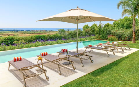 Villa Smeraldo - Sea Front | By Rocco Forte Villas: Möbel, Eigentum, Pflanze, Himmel, Regenschirm, Tabelle, Schatten, Azurblau, Gartenmöbel, Baum
