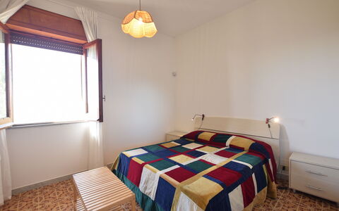Punta Braccetto Fronte Mare: Bett, Schlafzimmer, Wand, Interior Design, Fussboden, Bettdecke, Holz, Flooring, Bedding, Zimmer
