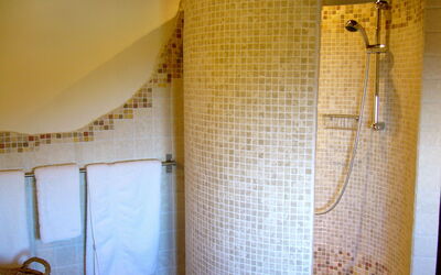 Badezimmer mit runder Dusche aus Travertinmosaik